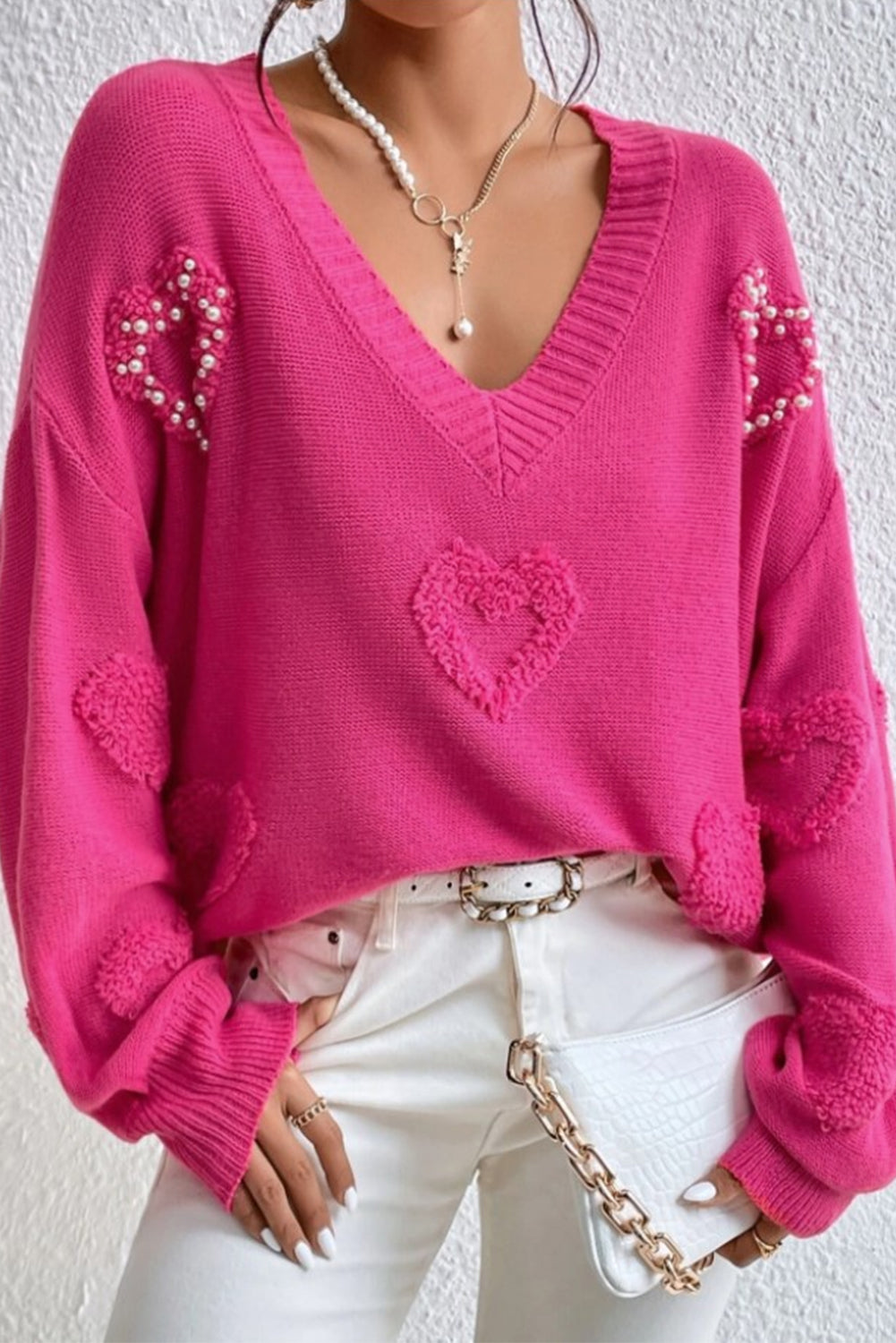Rosenroter, perlenverzierter pullover mit v-ausschnitt und flauschigen herzen