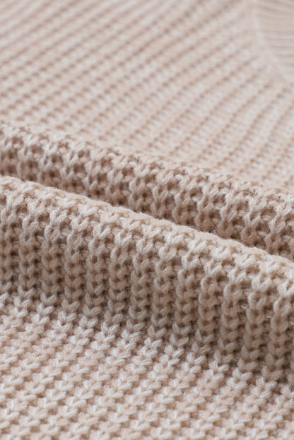 Pergamentfarbener pullover mit zopfstrickärmeln und hängeschultern