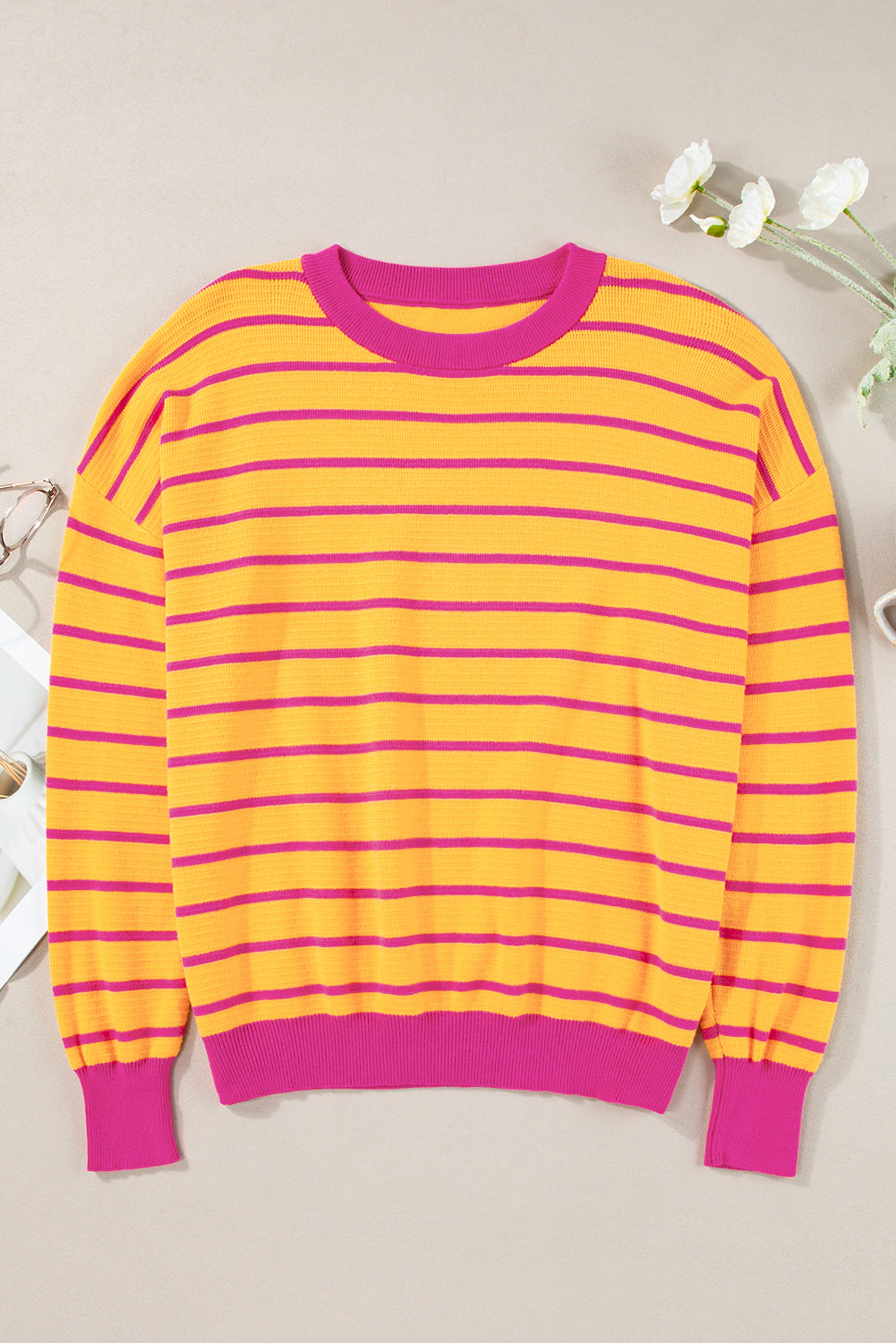 Orangefarbener gestreifter pullover mit rundhalsausschnitt und losen schultern
