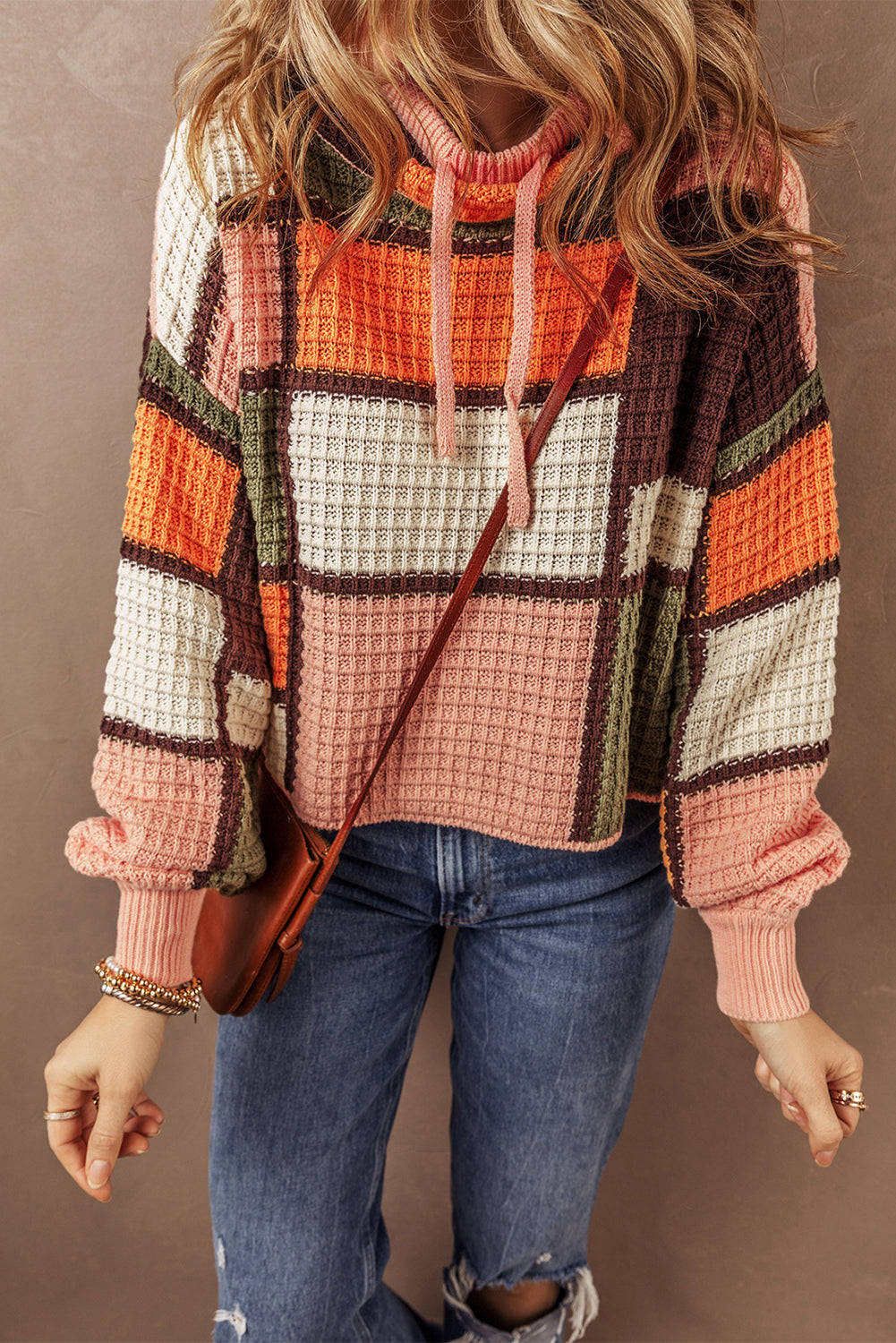 Orangefarbener block-waffelstrickpullover mit kordelzug und rundhalsausschnitt
