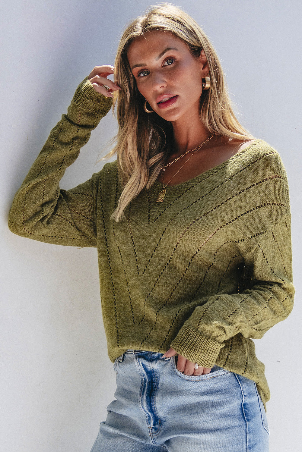 Salbeigrüner pullover mit v-ausschnitt und tropfenschulter in ösenform