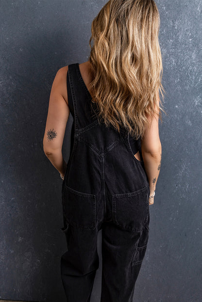 Schwarzer denim-overall mit verstellbaren schnallenriemen und mehreren taschen