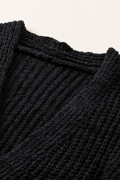 Schwarzer strickcardigan mit knöpfen an der vorderseite und hängeschultern