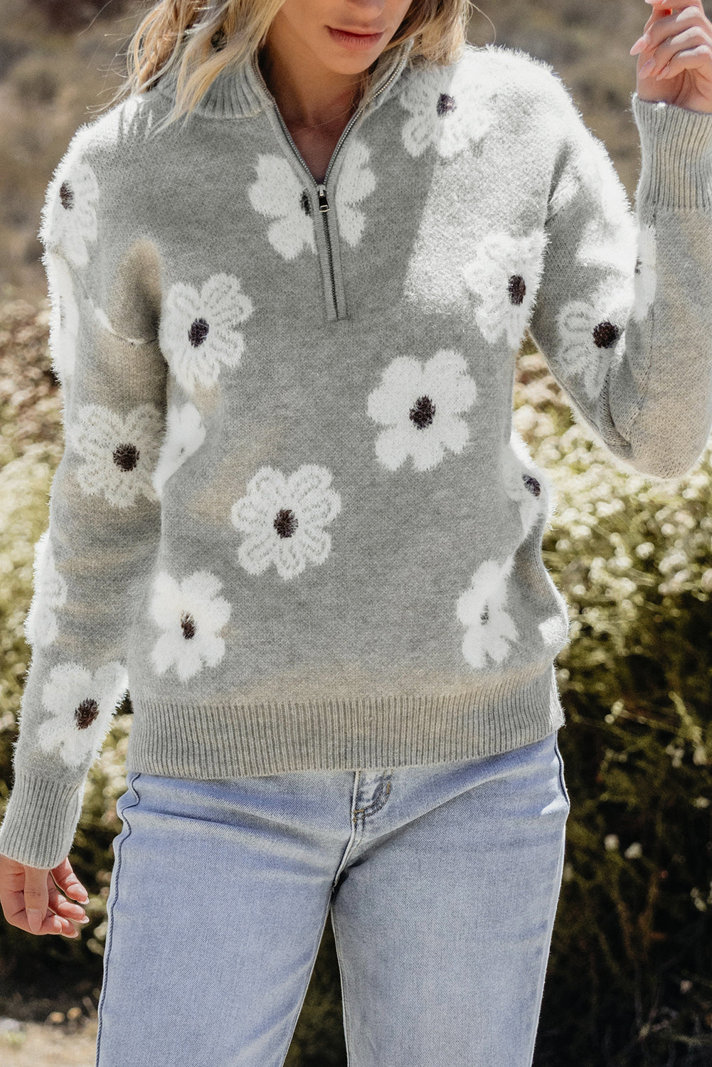 Grauer pullover mit floralem muster und halbem reißverschluss an der schulter