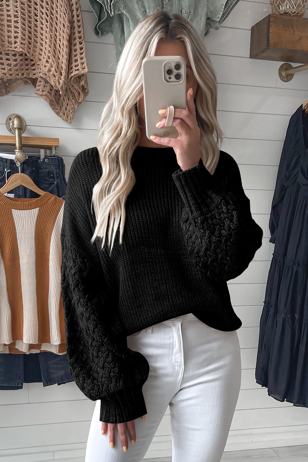 Schwarzer pullover mit zopfstrickärmeln und hängeschultern
