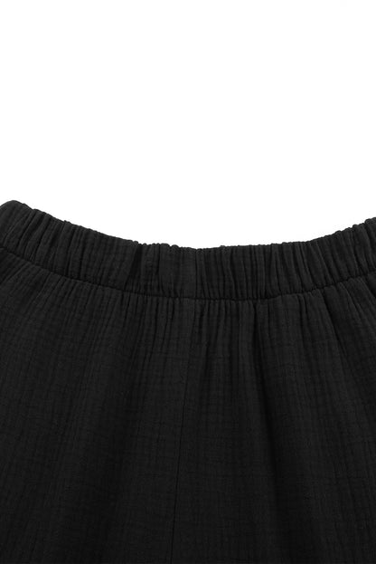 Schwarze strukturierte hose mit hoher taille und gerafftem glockenboden