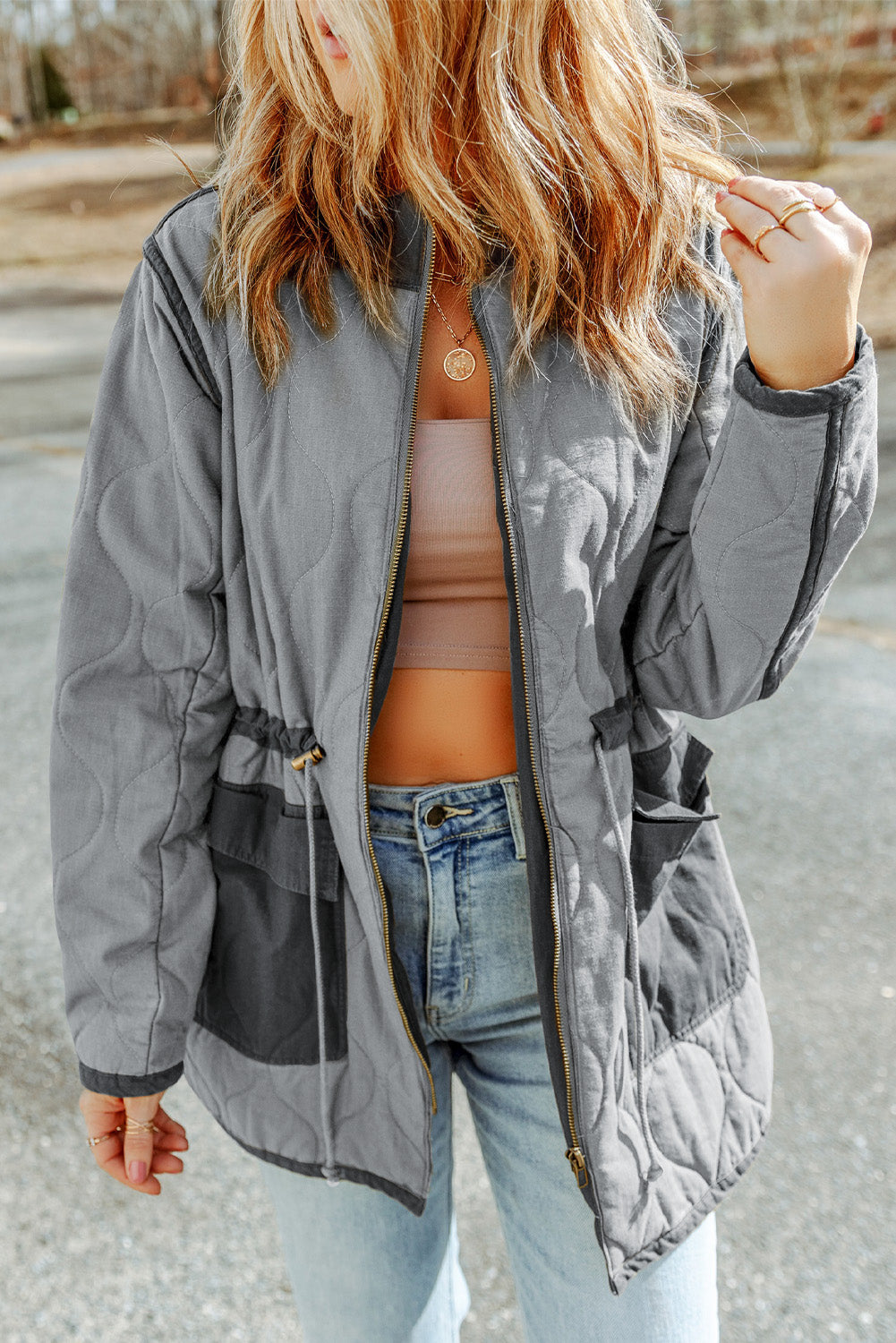 Steppjacke mit kordelzug und grauen steppnähten