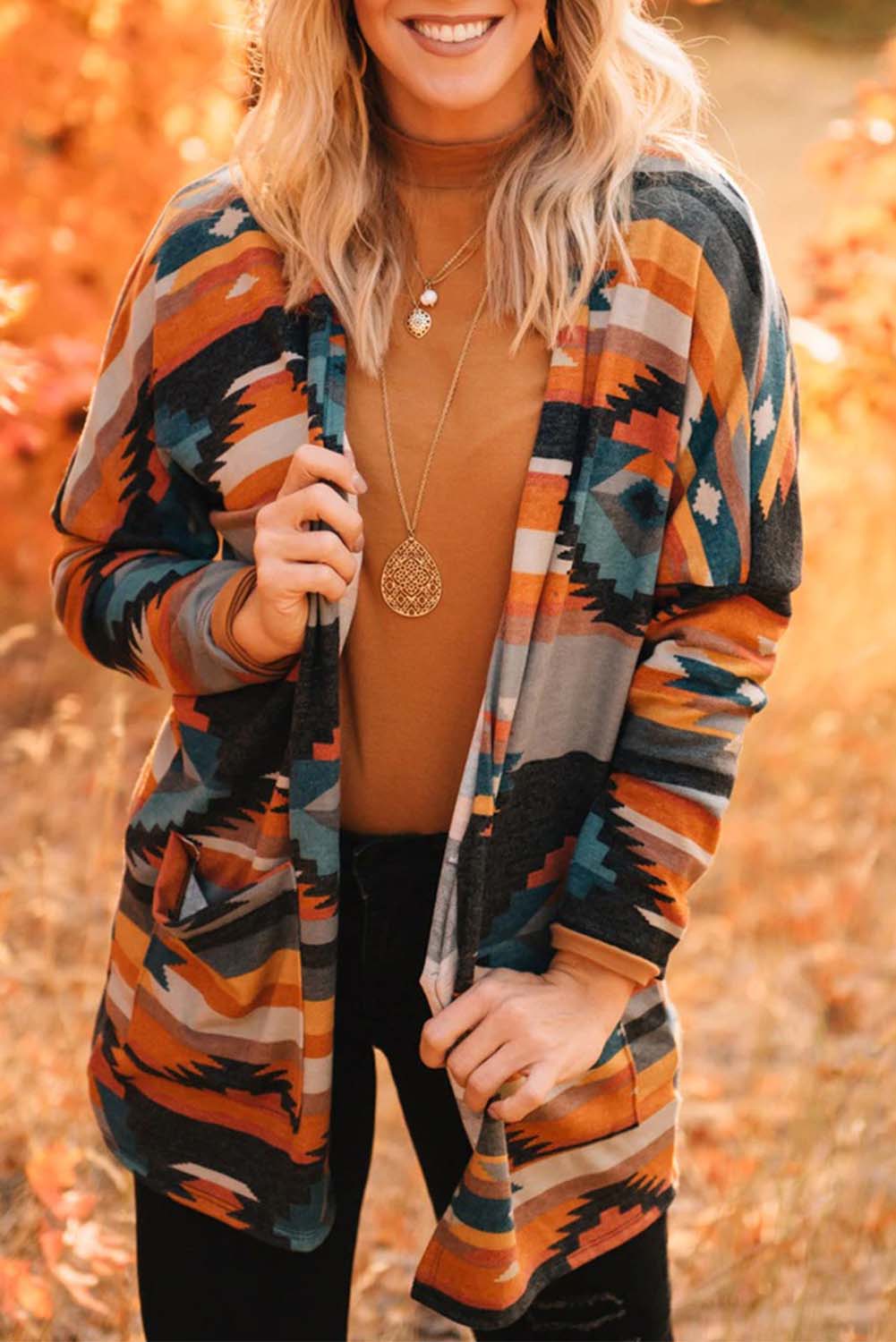 Orangefarbene strickjacke mit aztekischem stammesmuster