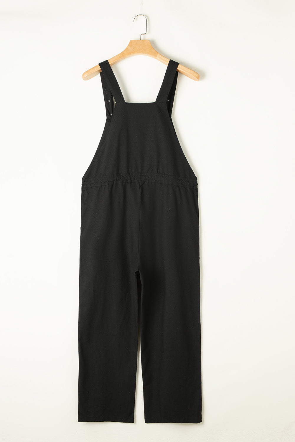 Schwarzer overall mit geknöpften riemen und kordelzug