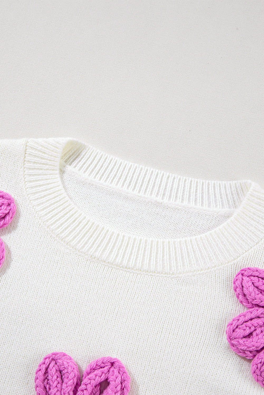 Weißer gehäkelter grobstrickpullover mit blumenmuster