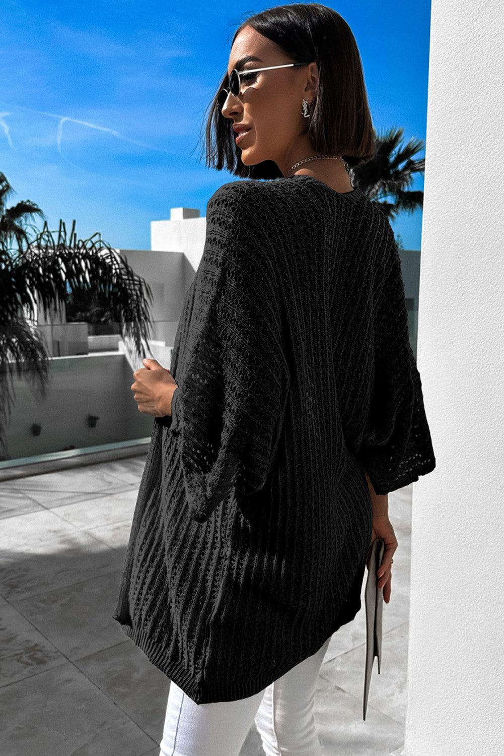 Schwarze strickjacke mit ausgehöhlten armbändern und ärmeln