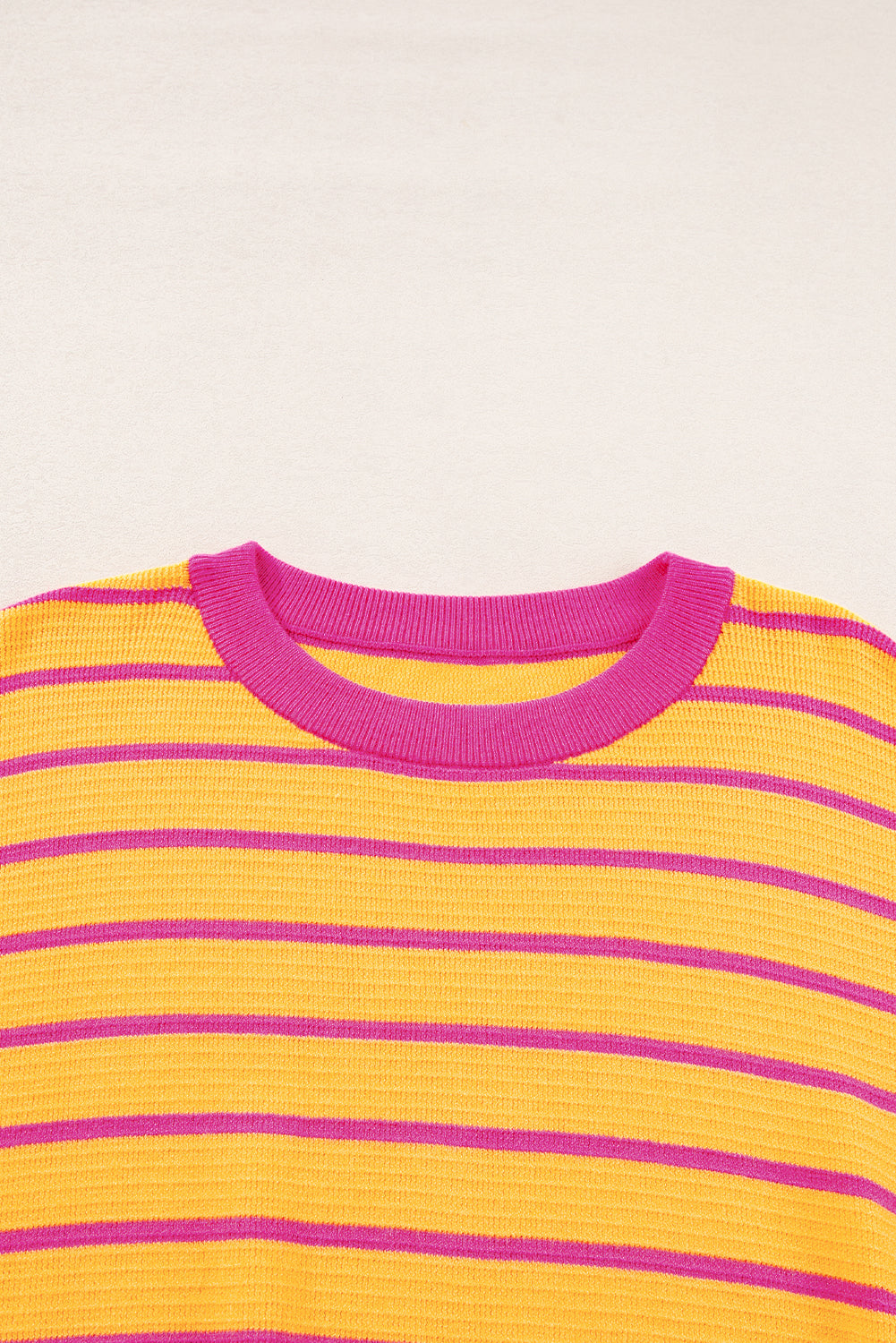 Orangefarbener gestreifter pullover mit rundhalsausschnitt und losen schultern