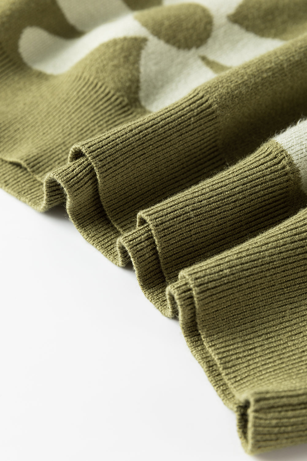 Spinatgrüner pullover mit großer blume und rippstrickmuster