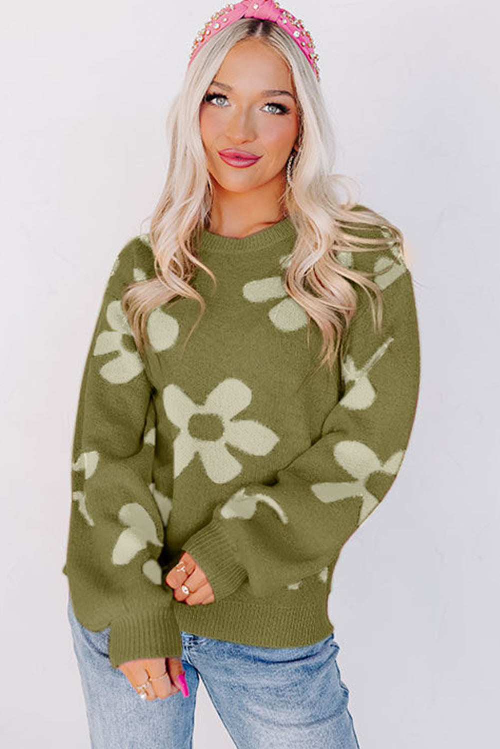 Spinatgrüner pullover mit großer blume und rippstrickmuster