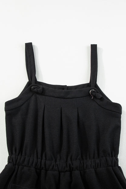 Schwarzer jumpsuit mit geknoteten trägern und strukturiertem kordelzug