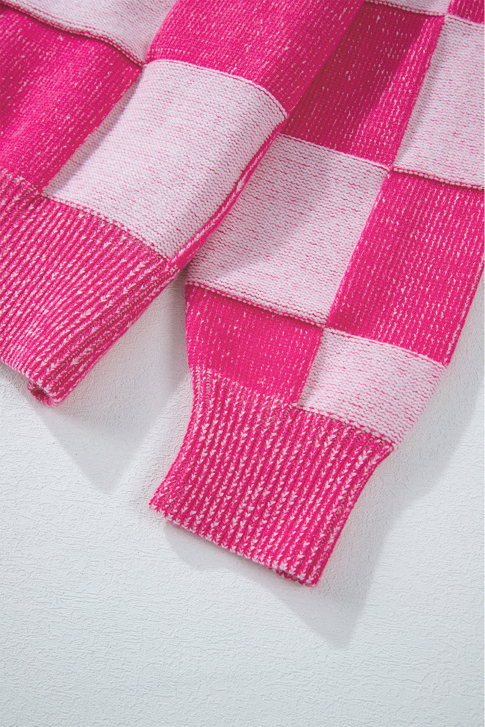 Rosa karierte strickjacke mit v-ausschnitt und geknöpften schultern