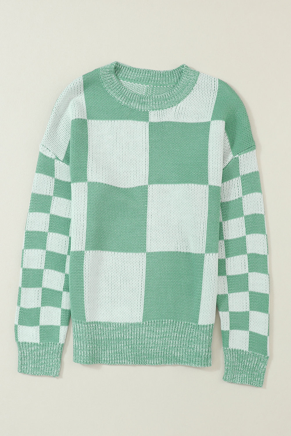 Mintgrüner pullover mit karomuster und schultertaschen