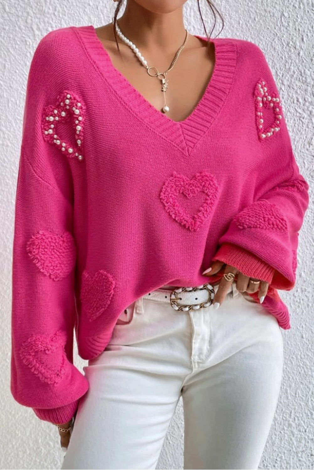 Rosenroter, perlenverzierter pullover mit v-ausschnitt und flauschigen herzen