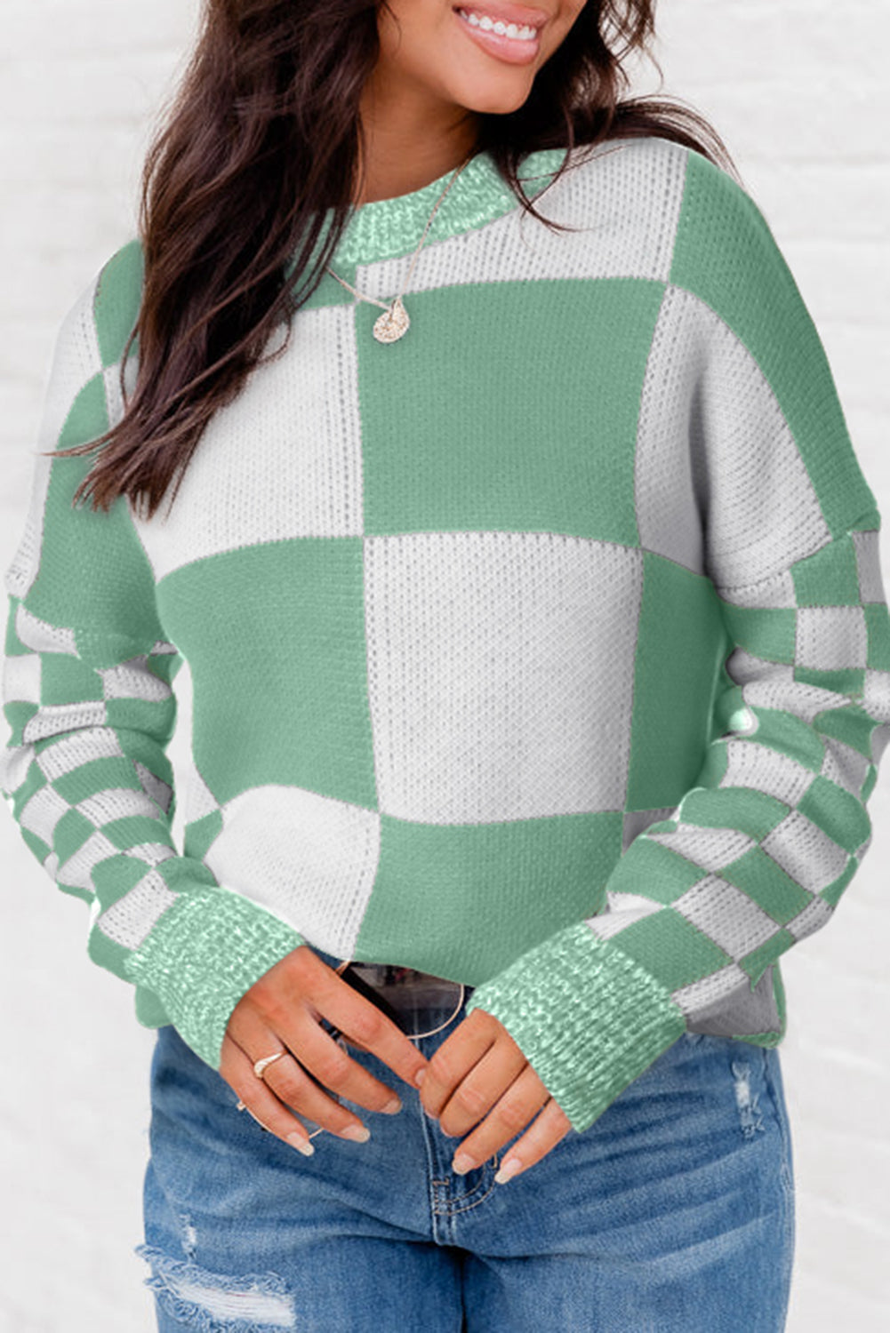 Mintgrüner pullover mit karomuster und schultertaschen