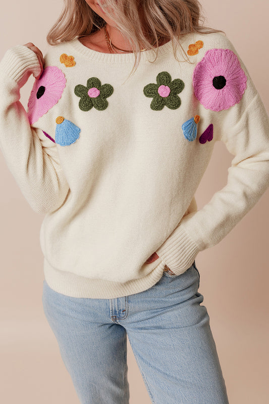 Beige gestrickter pullover mit blumenmuster und geripptem rand