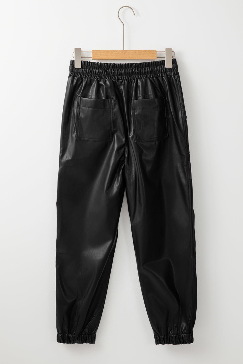 Schwarze kunstleder-jogginghose mit gesmokter taille und kordelzug