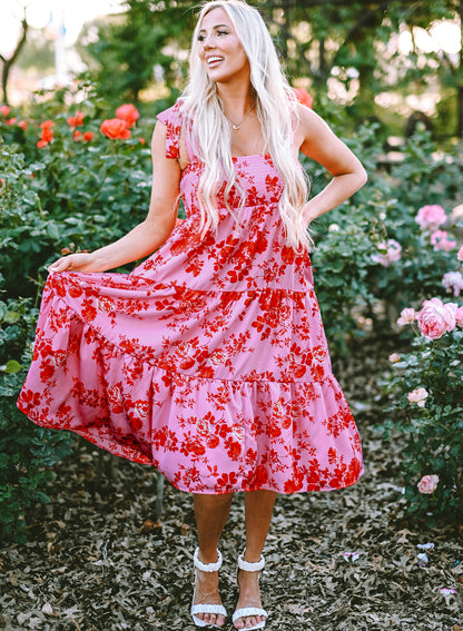 Rosa kleid mit gestuften blumenträgern und krawattenschultern