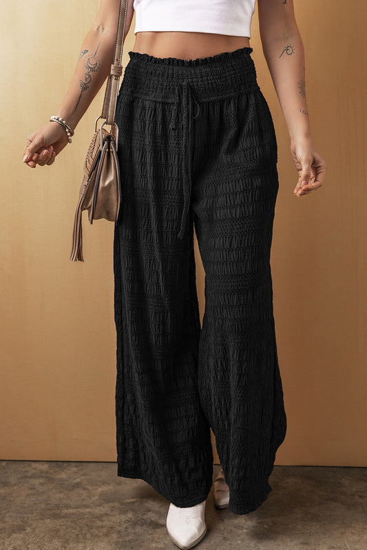 Schwarze strukturierte hose mit breiter gesmokter taille und loser hose