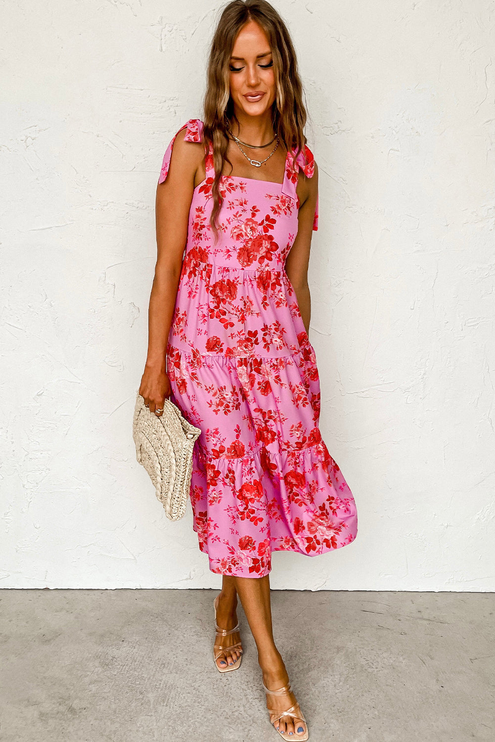 Rosa kleid mit gestuften blumenträgern und krawattenschultern