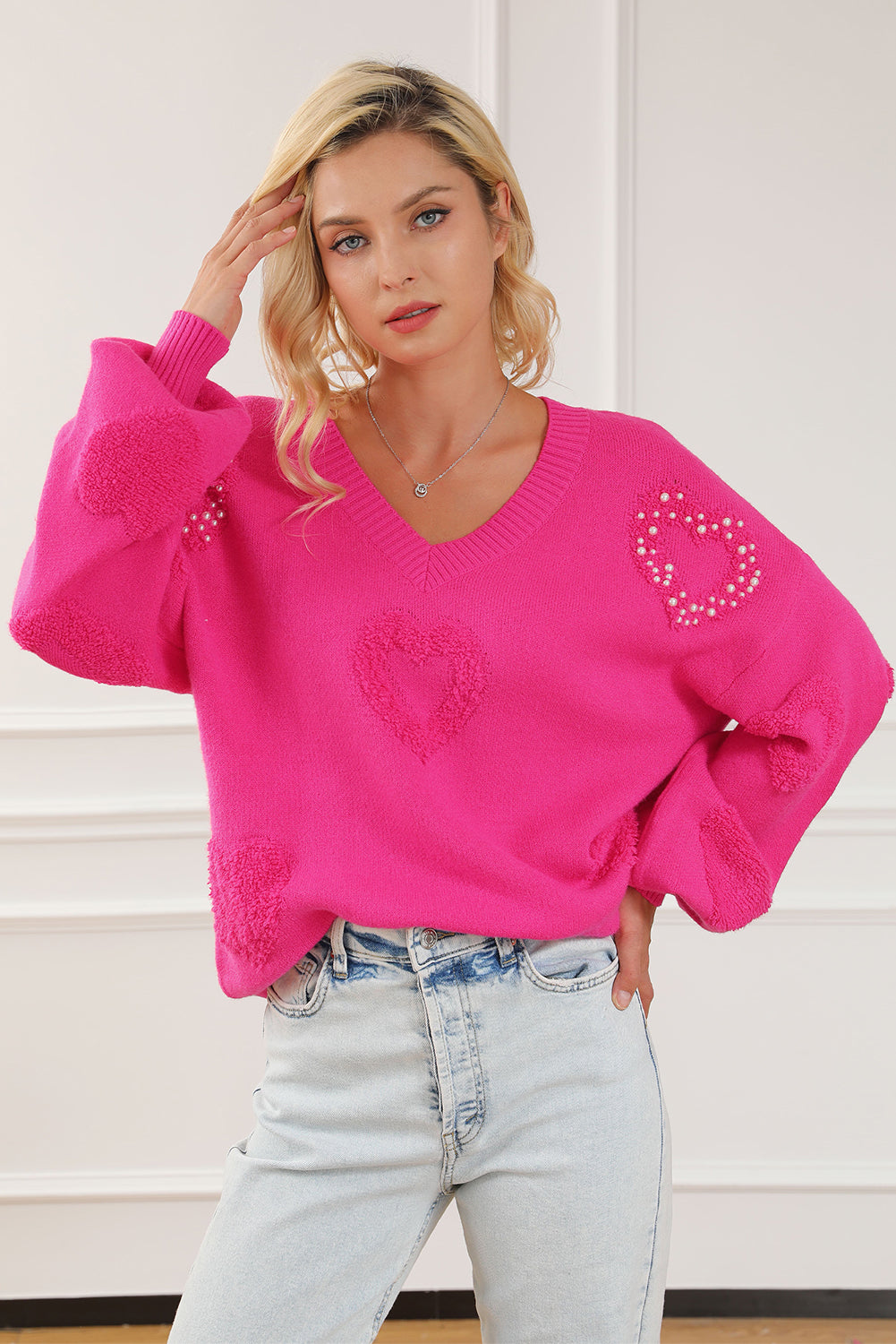 Rosenroter, perlenverzierter pullover mit v-ausschnitt und flauschigen herzen