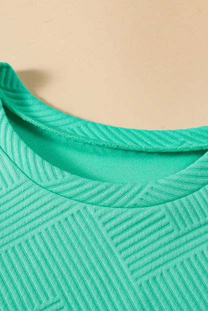 Mintgrünes strukturiertes t-shirt-kleid mit langen ärmeln