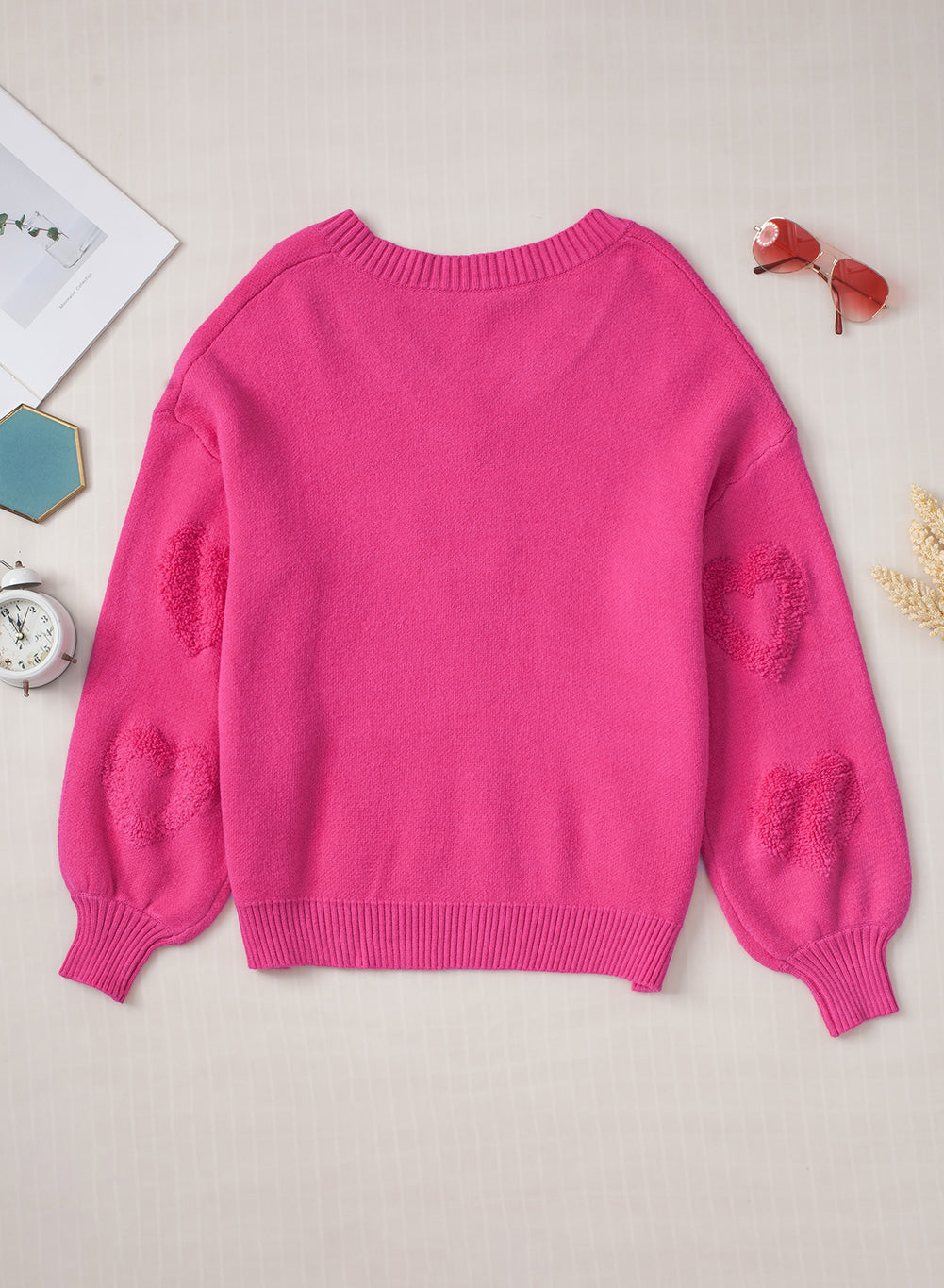 Rosenroter, perlenverzierter pullover mit v-ausschnitt und flauschigen herzen