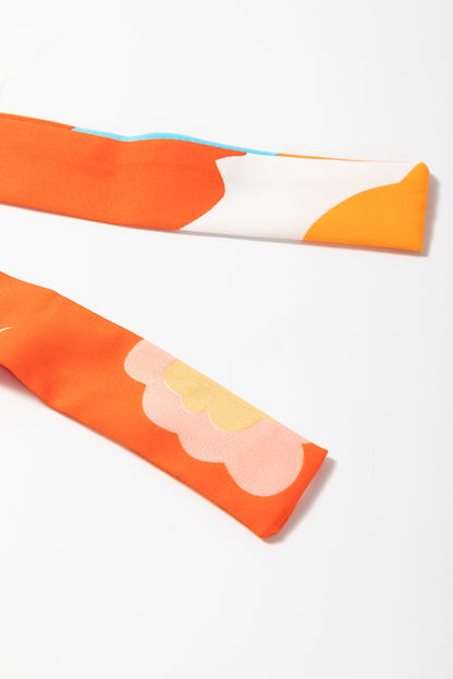 Orangefarbenes maxikleid mit selbstgebundenen trägern und gesmokter oberweite
