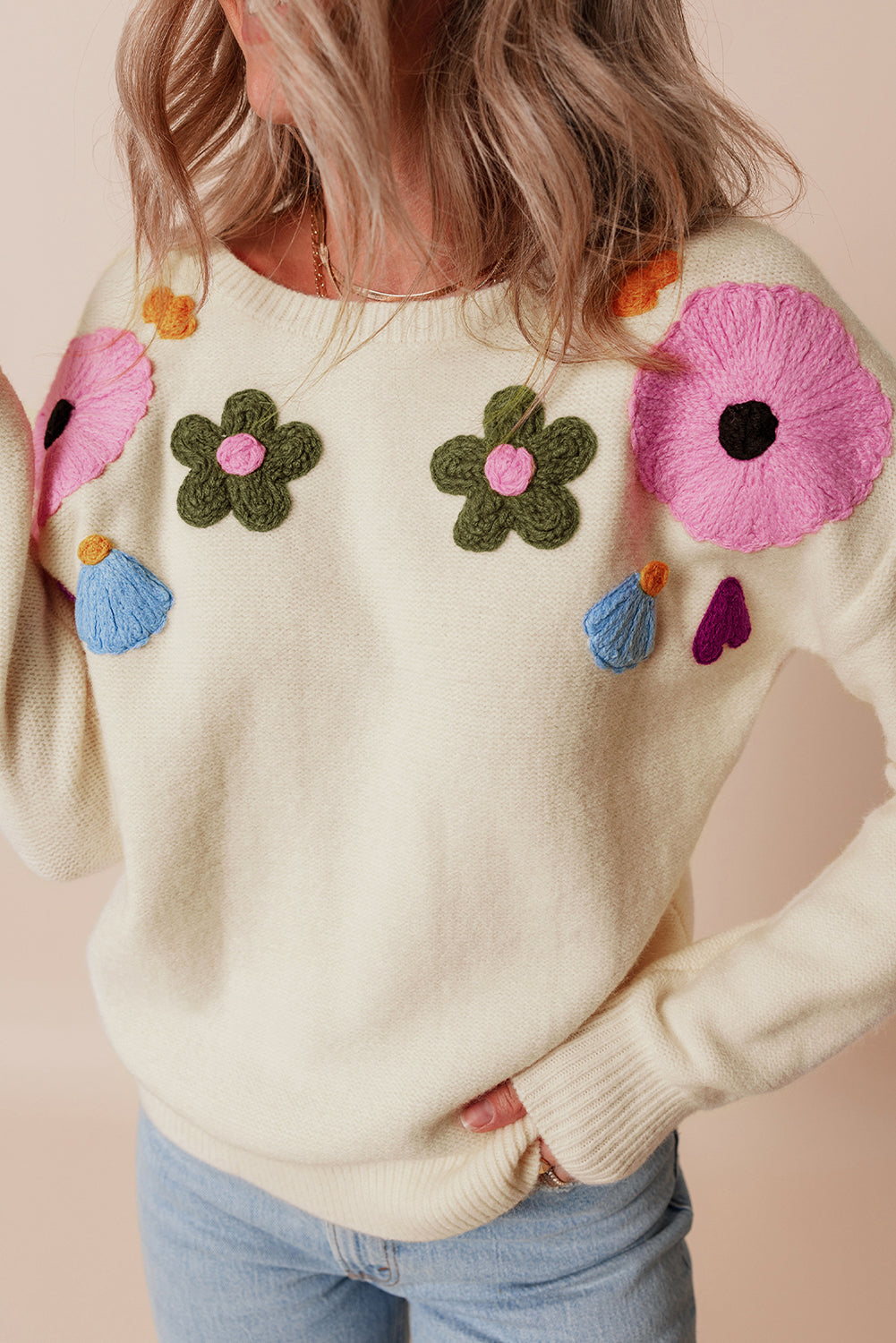 Beige gestrickter pullover mit blumenmuster und geripptem rand