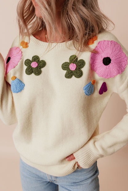 Beige gestrickter pullover mit blumenmuster und geripptem rand