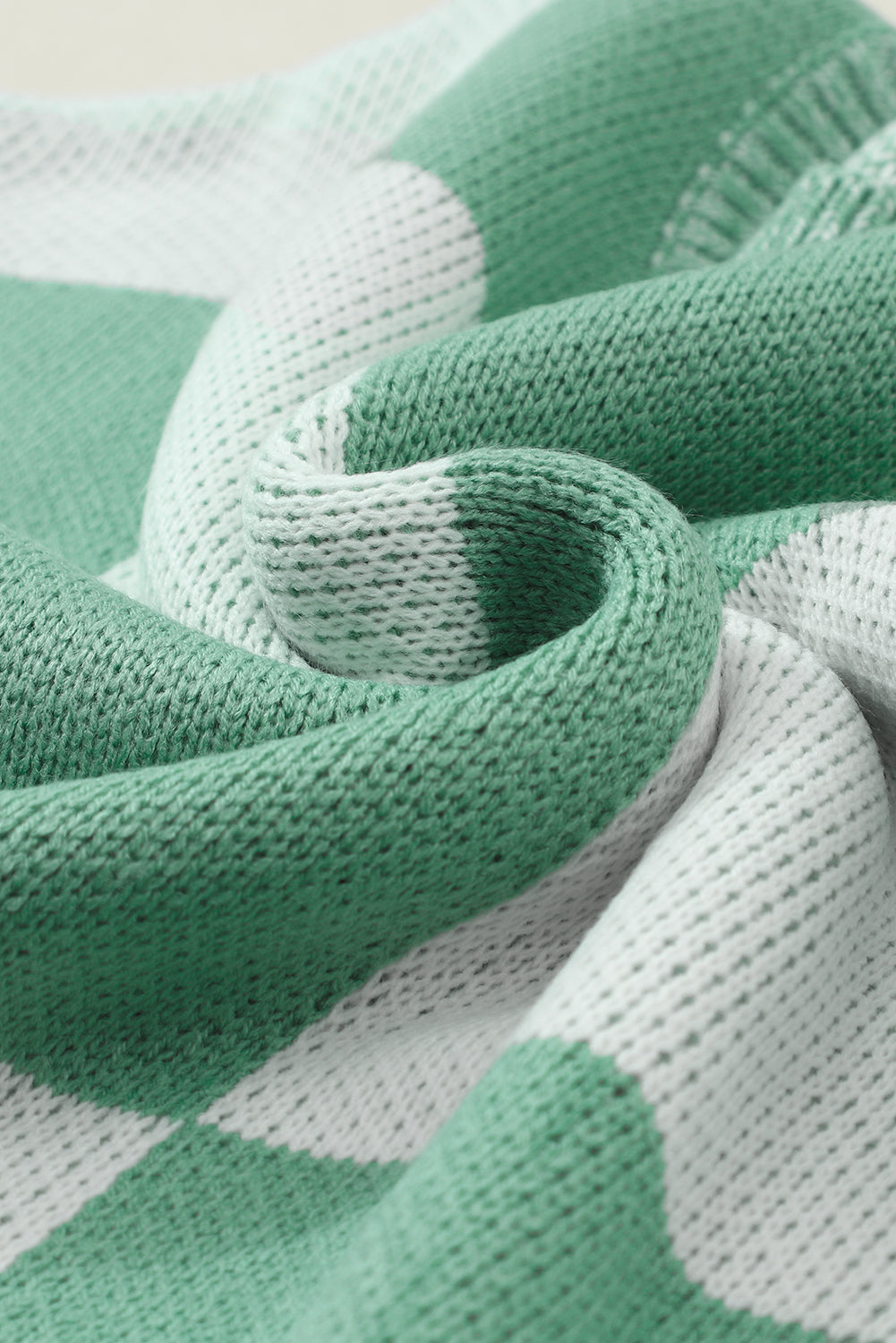 Mintgrüner pullover mit karomuster und schultertaschen