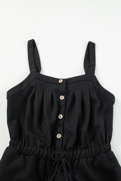 Schwarzer jumpsuit mit geknoteten trägern und strukturiertem kordelzug