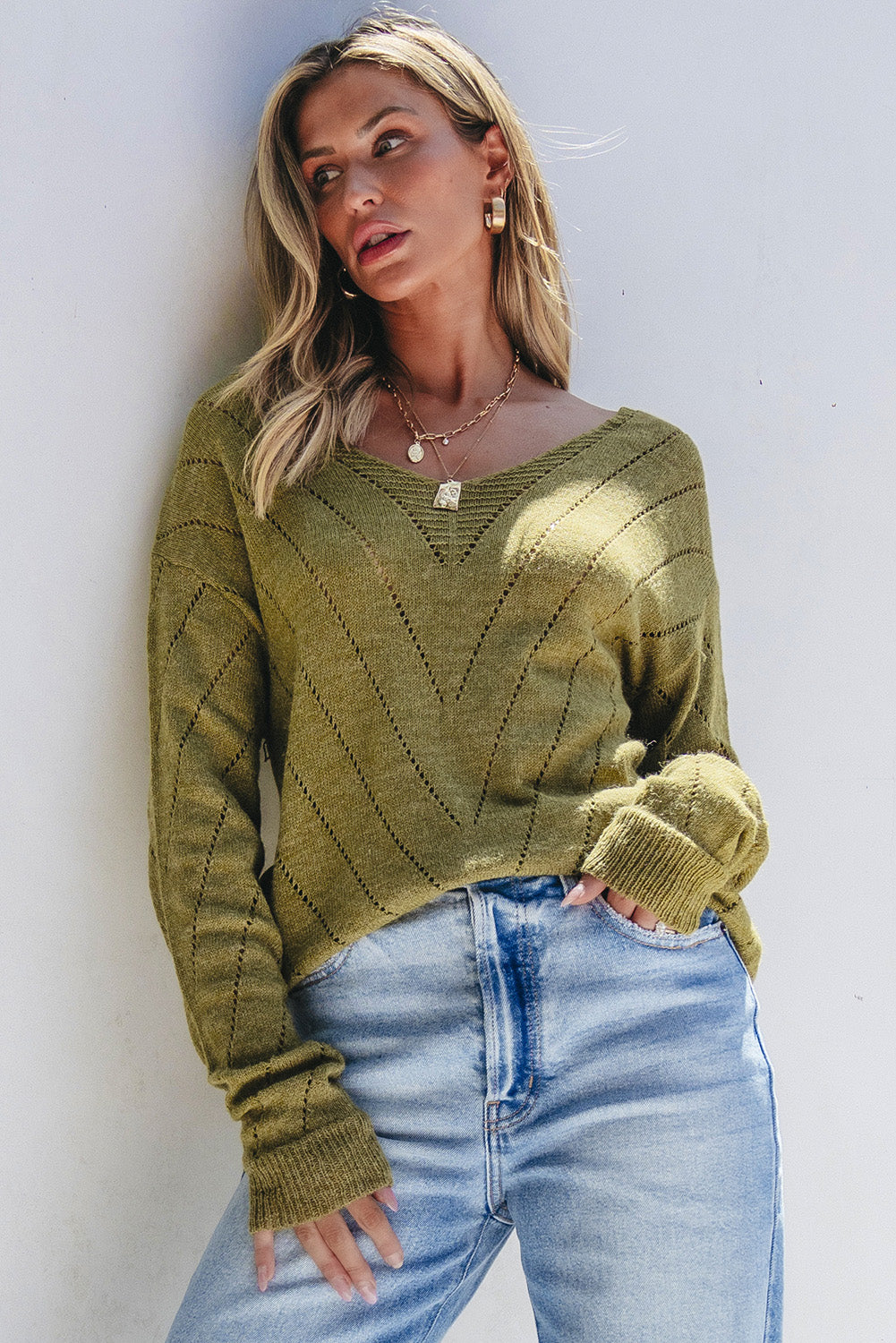 Salbeigrüner pullover mit v-ausschnitt und tropfenschulter in ösenform