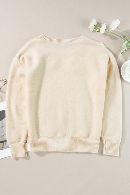 Beige gestrickter pullover mit blumenmuster und geripptem rand