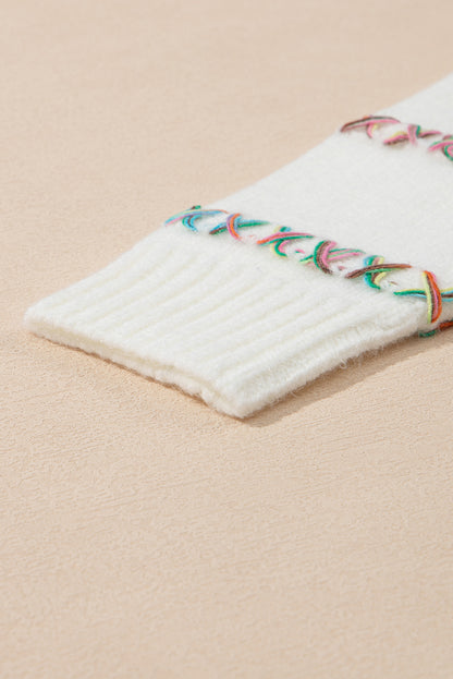 Weißer pullover mit gekreuzten schultern und bunten maschen