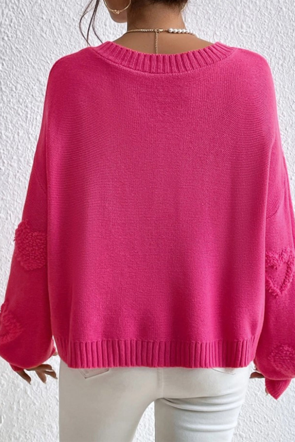 Rosenroter, perlenverzierter pullover mit v-ausschnitt und flauschigen herzen