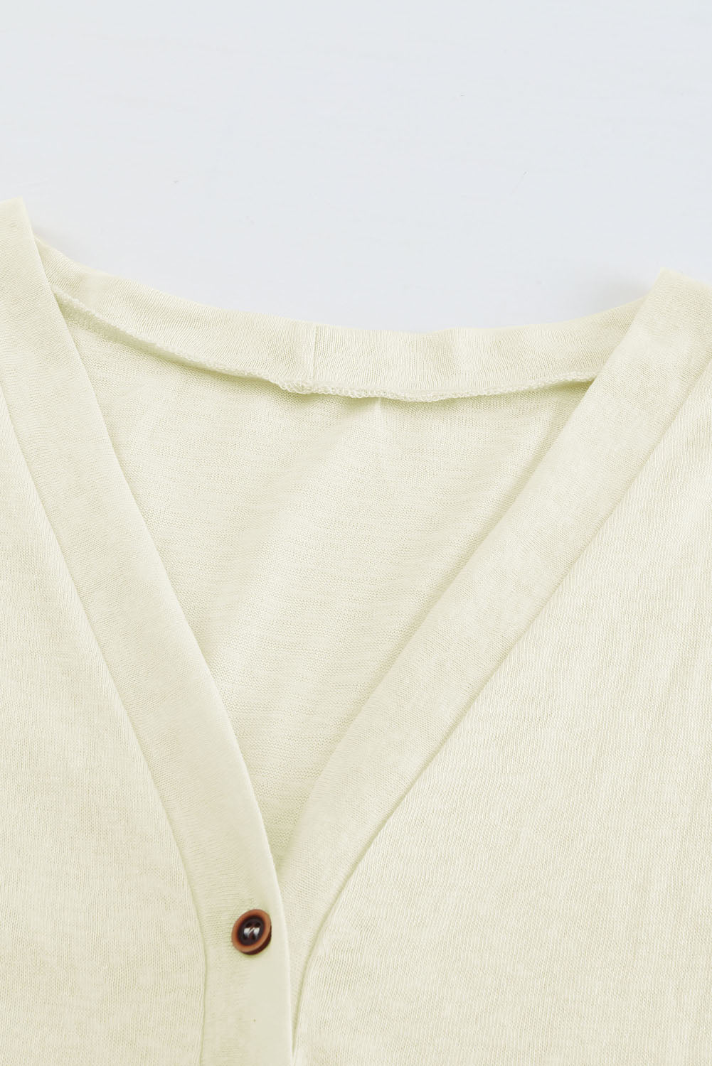 Beigefarbene strickjacke mit knöpfen und offener vorderseite