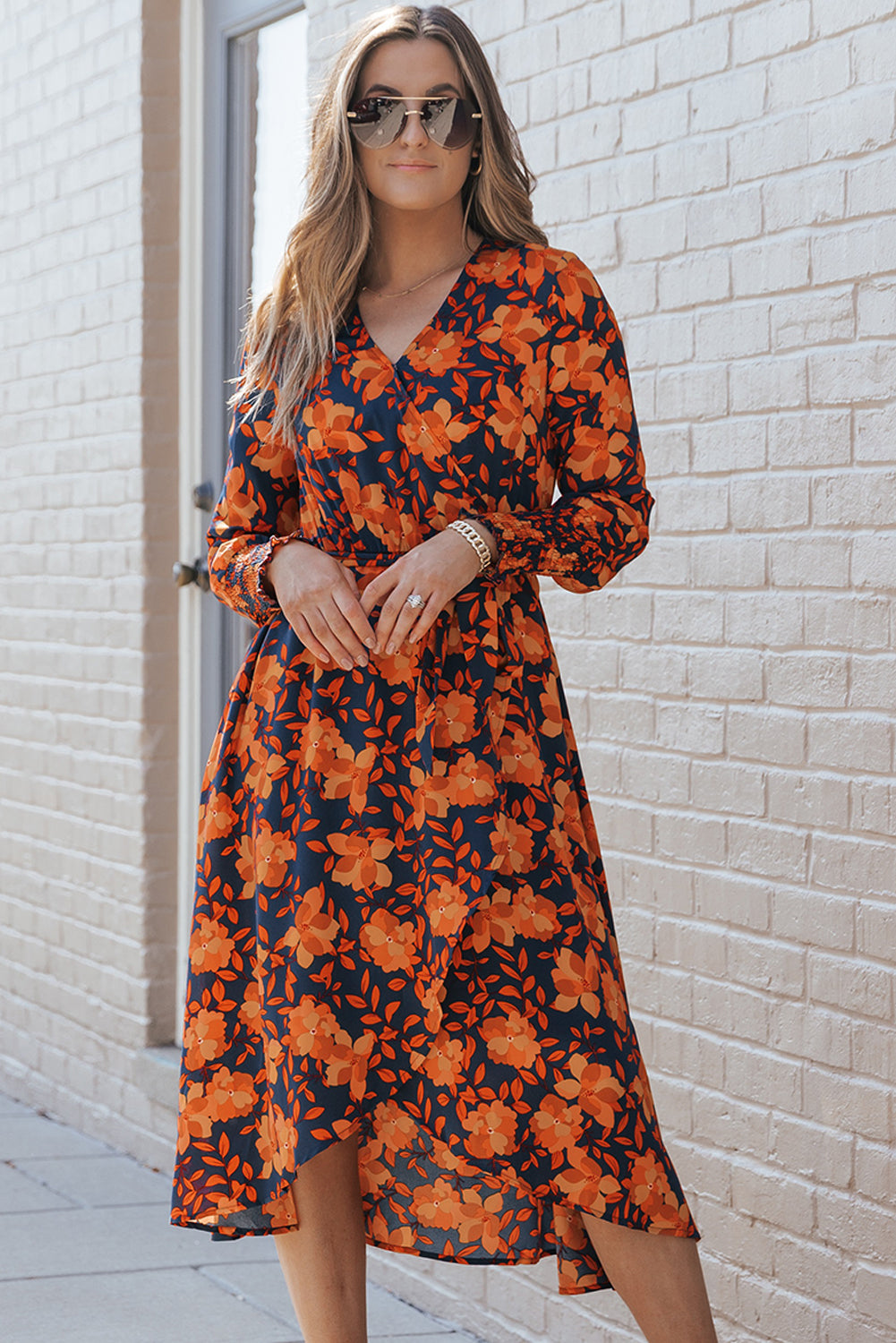 Orangefarbenes kleid mit gürtel und blumenmuster und faux wrap