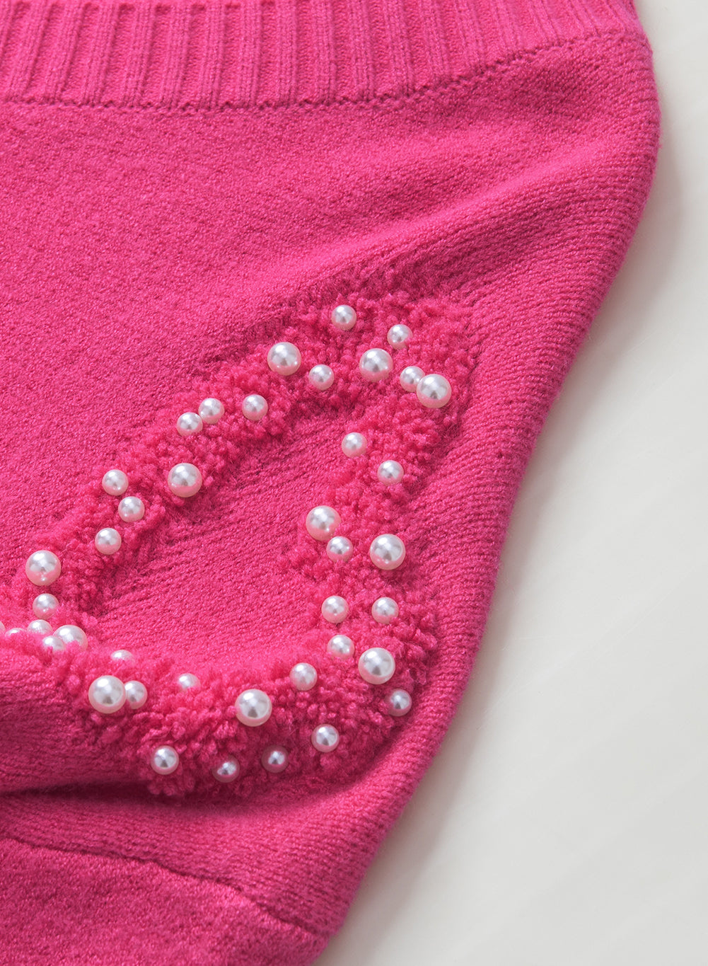 Rosenroter, perlenverzierter pullover mit v-ausschnitt und flauschigen herzen