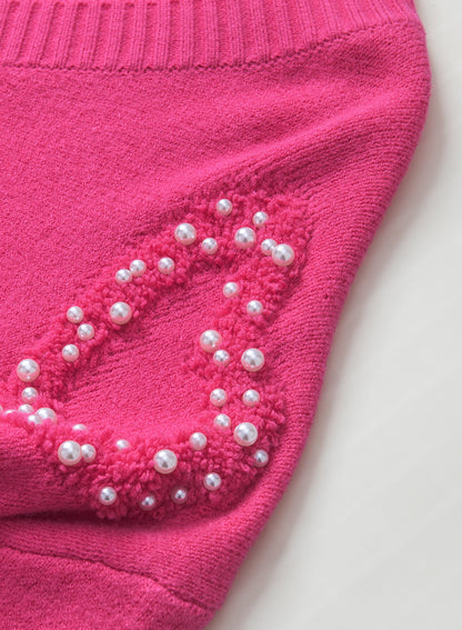 Rosenroter, perlenverzierter pullover mit v-ausschnitt und flauschigen herzen