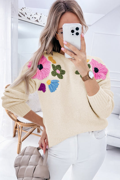 Beige gestrickter pullover mit blumenmuster und geripptem rand