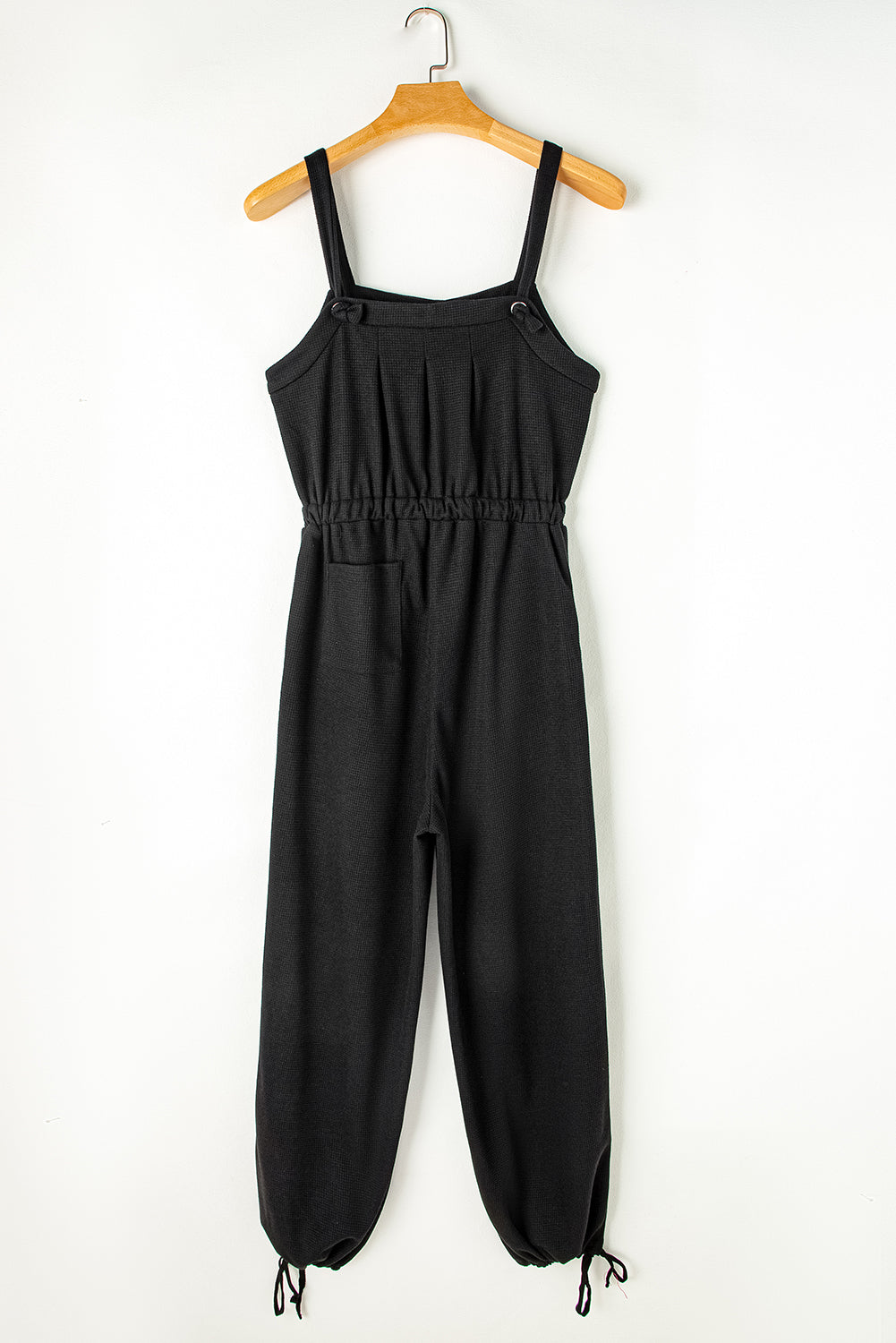 Schwarzer jumpsuit mit geknoteten trägern und strukturiertem kordelzug