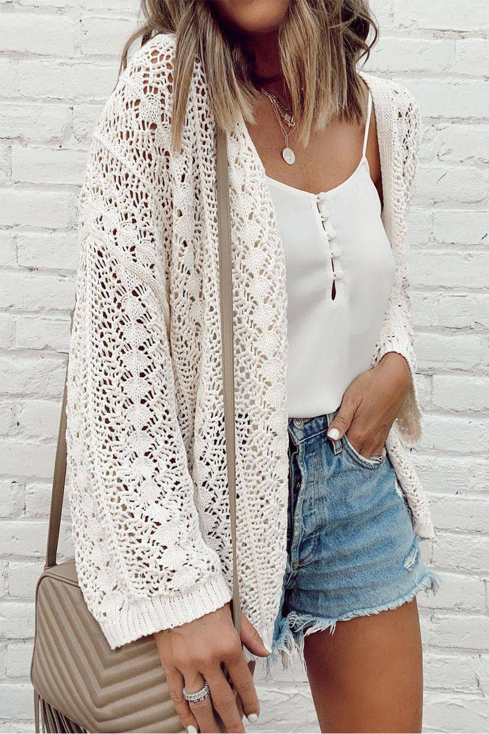 Weißer modischer strickcardigan mit hohlen schultern