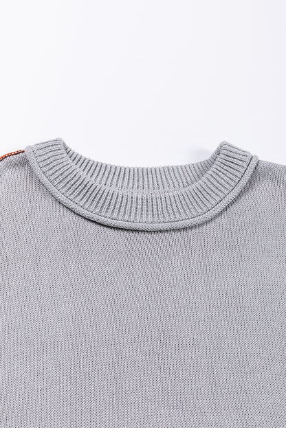 Grauer colorblock-pullover mit gerippten ärmeln und zierleisten
