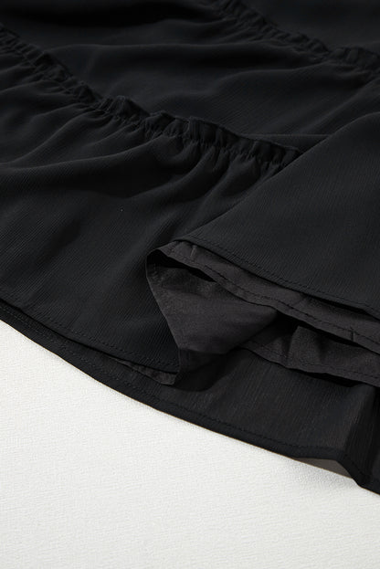 Schwarzes ärmelloses kleid mit v-ausschnitt und rüschenbesatz