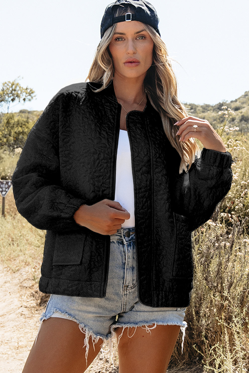 Schwarze gesteppte jacke mit blumenmuster